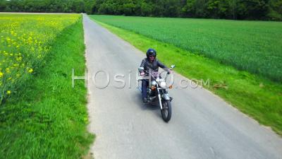 Biker On A Country Road, Followed By Drone