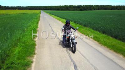 Biker On A Country Road, Followed By Drone