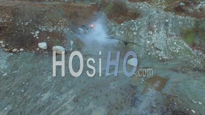 Car Fire On Turned Over Vehicle At Dusk In An Abandoned Gravel Pit. - Video Drone Footage