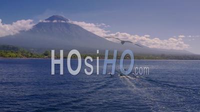 Fishing Boat And Mount Agung With Wispy Activity Between Eruptions - Video Drone Footage