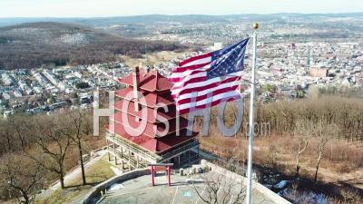 Aerial View Over Reading Pennsylvania Asian Temple And American Flag With City Background - Video Drone Footage