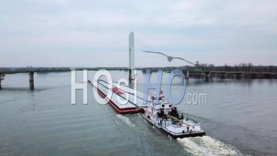 Aerial View Of A Coal Barge Pushed By Tugboat Moving Up The Mississippi River Near Burlington Iowa - Video Drone Footage