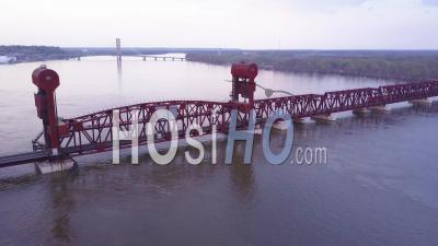 Aerial View Of A Coal Freight Train Crossing A Long Suspension Bridge Over The Mississippi River - Video Drone Footage