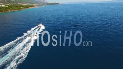 Aerial View Of Adventure Boat Towing Four Innertubes For A Tubing Adventure Off The Coast Of Croatia - Video Drone Footage