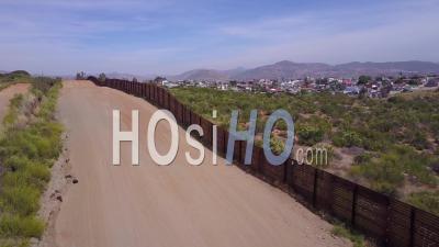 Aerial View Along The U.S Mexican Border Wall Fence Reveals The Town Of Tecate Mexico - Video Drone Footage