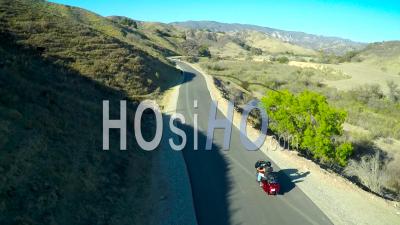 Vue Aérienne Sur Un Homme Conduisant Sa Moto Harley Sur La Route Ouverte - Vidéo Drone