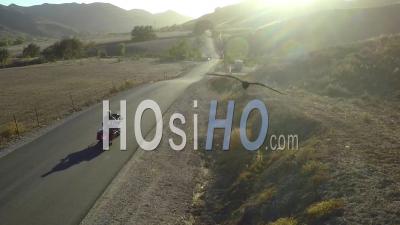 Aerial View Over A Man Riding His Harley Motorcycle On The Open Road And Into The Sunset - Video Drone Footage