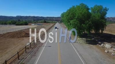 Aerial View Following A Man Riding An Electric Unicycle Down A Road In California - Video Drone Footage