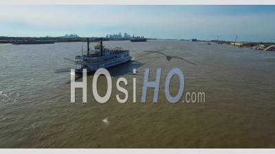 Very Good Aerial View Over A Paddlewheel Steamer On The Mississippi River With The New Orleans Skyline In Distance - Video Drone Footage