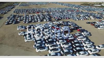 Aerial View Of New Import Cars Sitting In A Lot Awaiting Distribution And Sale - Video Drone Footage