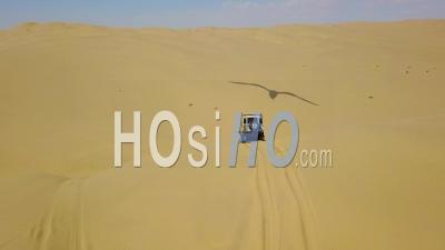 Aerial View Over 4wd Safari Land Rover 4x4 Driving Over Desert Sand Dunes In The Namib Desert, Namibia, Africa - Video Drone Footage