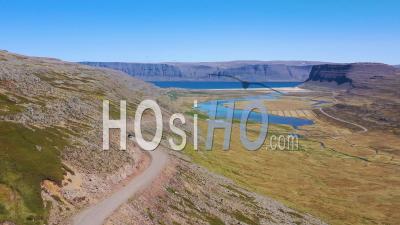 Vue Aérienne D'une Voiture Circulant Sur Un Chemin De Terre Avec Les Fjords De L'ouest Et Les Fjords D'islande - Vidéo Drone