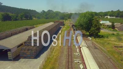 Steam Train Pushing Carriages Into Rural Station - Video Drone Footage