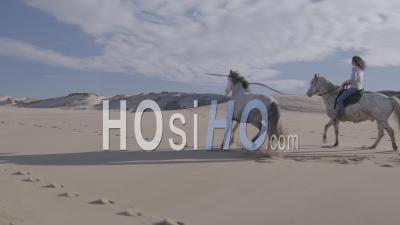 Woman Horse Riding With Her Two Horses In The Dunes - Aerial Video By Drone