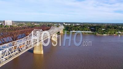 A Mississippi River Paddlewheel Steamship Going Under Three Steel Bridges Near Memphis, Tennessee - Aerial Video By Drone