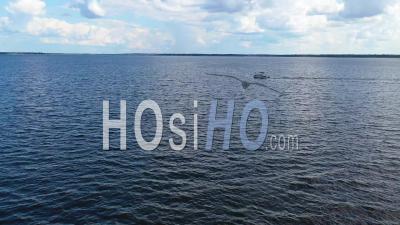 A Pontoon Pleasure Fishing Boat Traveling On Ross R Barnett Reservoir Near Old Trace Park, Jackson, Mississippi - Aerial Video By Drone