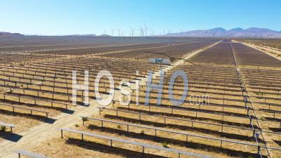 Une Ferme Solaire Révèle Un Parc éolien Au Loin, Le Désert De Mojave, En Californie, Suggère Des Sources D'énergie Verte Renouvelable Propre - Vidéo Aérienne Par Drone