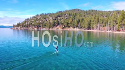 2020 - A Man Rides A Hydrofoil Efoil Electronic Surfboard Across Lake Tahoe, California In An Extreme Hydrofoiling Foil Sport Demonstration - Video Drone Footage