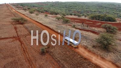 A School Bus Traveling On A Generic Rural Dirt Road On Molokai, Hawaii From Maunaloa To Hale O Lono - Aerial Video By Drone