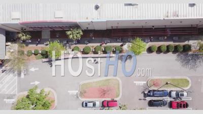  Big Line Of People Waiting Outside A Super Market With Empty Carts - Video Drone Footage