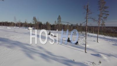 Two Snowmobiles Driving To A Snowy Forest Of Fir Trees, Tackasen, Sweden - Video Drone Footage