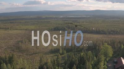 Aerial View Of A Helicopter Getting Close To Houses In Forest, Tackasen, Sweden - Video Drone Footage