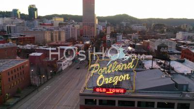 Aerial Around Portland Oregon Stag Deer Sign And Downtown Old Town Cityscape And Business District At Sunset Or Dusk. - Video Drone Footage