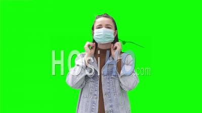 Young Woman Putting On Face Mask