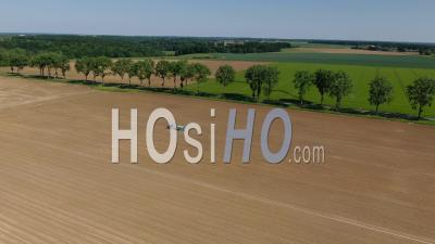 Tractor Working In The Field Under A Shiny Blue Sky, Drone Point Of View