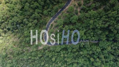 Images Aériennes D'une Voiture Circulant Sur Une Route Sinueuse Parmi La Forêt D'esterel, Vue Par Drone