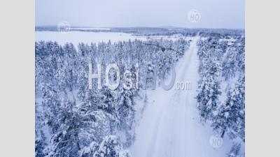 Conditions Routières Dangereuses De La Route D'hiver Couverte De Neige Glacée Dans Le Cercle Polaire Arctique En Laponie, Finlande Drone