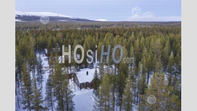Prise De Vue Drone Photo De Cabine En Bois Dans La Forêt éloignée, Avec Paysage D'arbres Couverts De Neige Et Montagnes En Laponie, Finlande