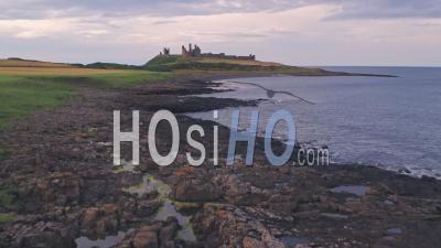 Iconic English Dunstanburgh Castle At Sunset, Northumberland, England, Uk. Aerial Drone View