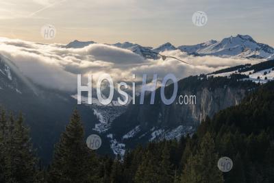 Dramatic Snowy Winter Mountain Landscape With Low Misty Clouds And Forests At The Ski Resort Of Morzine, Alps, France, Europe