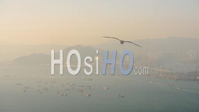 Lots Of Container Cargo Freight Ship Sailing At Victoria Harbour With Stonecutters Highway Bridge On A Foggy Morning In Hong Kong.- High Angle Shot