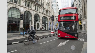 Quiet Roads And Streets In The City In Central London With Just A Red London Bus For Public Transport, And A Cyclist On A Bicycle Taken During Coronavirus Covid-19 Lockdown In England, Uk, Europe