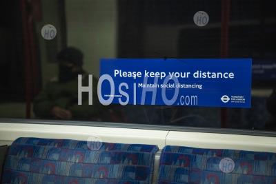 Personne Portant Un Masque Facial Dans Les Transports Publics, Avec Des Informations Sur Le Coronavirus Covid-19 Sign In London Underground Tube Train Transport Pour La Distance Sociale En Angleterre, Royaume-Uni