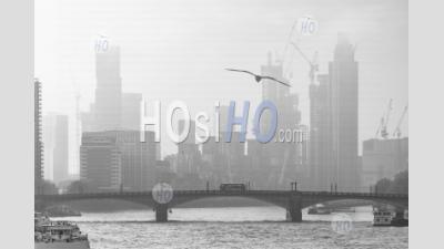 Black And White Atmospheric City In Misty Foggy Weather With Central London City Skyline, Iconic Red London Bus Driving And Skyscrapers, Shot In Coronavirus Covid-19 Lockdown In England, Uk