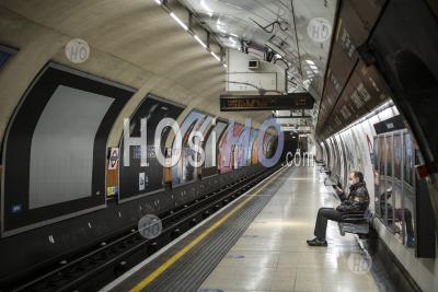 Quiet, Empty London Underground Tube Station In Coronavirus Covid-19 Pandemic Lockdown, With One Lone Person On Public Transport Train Platform During Travel Ban