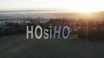 Aerial Drone Video Of Typical English Countryside And Fields With Sheep And A Village In Beautiful British Scenery In The Cotswolds At Sunrise In Beautiful Morning Light At Longborough, Gloucestershire, England, United Kingdom