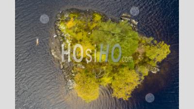  Wild Swimmer Enjoys A Bracing Autumnal Swim Around A Small Tree Covered Island In The Middle Of Loch Chon In Loch Lomond And Trossachs National Park, Scotland, Uk - Aerial Photography