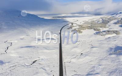 Aerial View Of A82 Road Crossing Rannoch Moor Covered In Snow During Winter, Highlands,Scotland, Uk - Aerial Photography