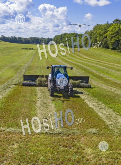 Farmer Pulls Hay Rake In Michigan Field - Aerial Photography