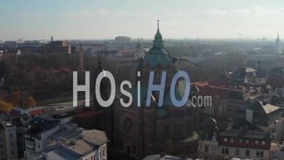 Scenic View Of A Cathedral In Winter Sunlight With Green Roof And Church Tower In Munich, Germany Neighborhood Right By The Isa River - Video Drone Footage