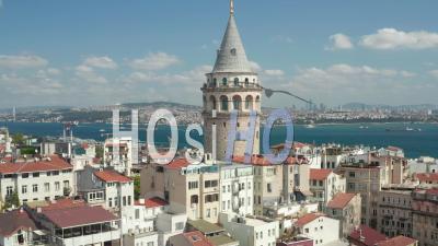 Ancient Galata Tower In Center Of Istanbul On Clear Blue Sky Day, Crane Shot Up Revealing Bosphorus River - Video Drone Footage