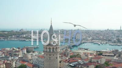 Passing Galata Tower Revealing Galata Bridge Over Bosphorus With Beautiful Clear Blue Sky, Slow Aerial Forward - Video Drone Footage