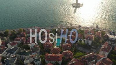 Hotel Resort On Bosphorus Riverside With View On Maiden's Tower In Beautiful Afternoon Light, Slow Forward Aerial Tilt Down - Video Drone Footage