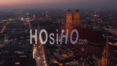 The Famous Frauenkirche Church Cathedral In Munich At Night, Aerial Dolly Forward Approaching Two Towers Of Beautiful Old Building, Scenic City Lights Glowing - Video Drone Footage