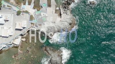 Aerial Overhead Top Down View Of Greek Fishing Village With Waves Crashing Into Rocks On Milos Island 4k - Video Drone Footage