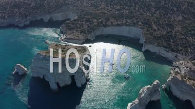 Aerial Wide Establishing Shot Of Tropical Bay In Greece With White Rocks And Boats In The Ocean 4k - Video Drone Footage
